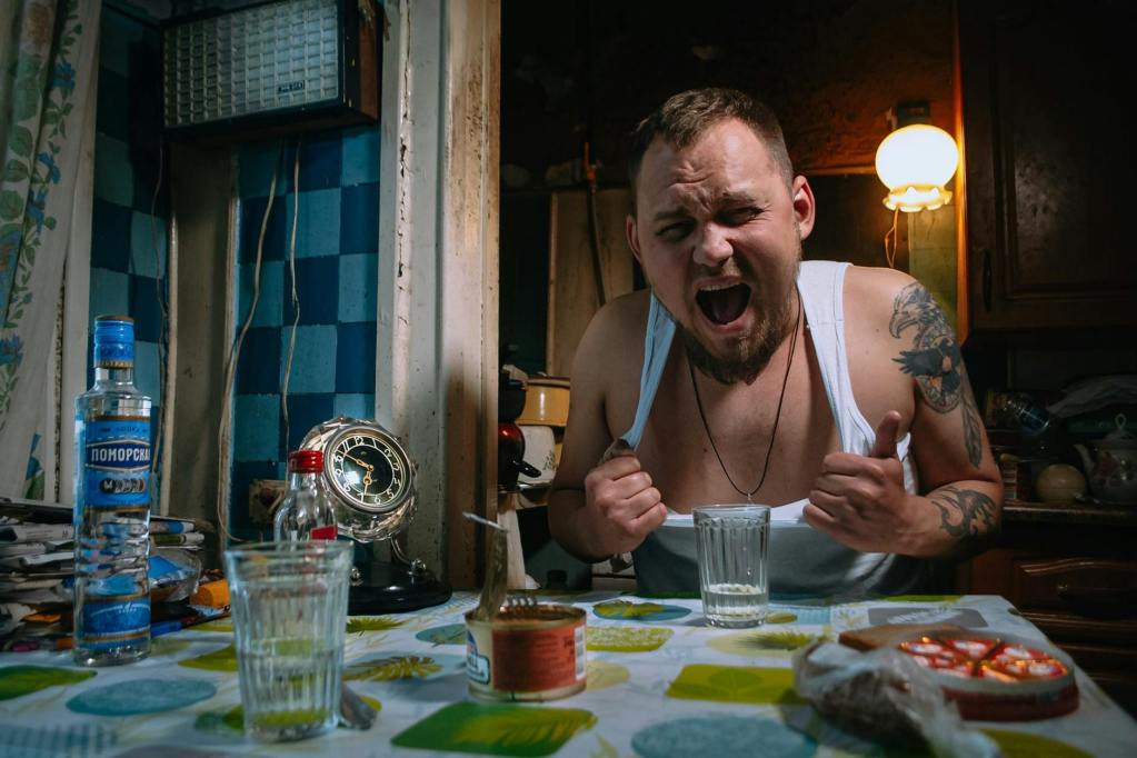 man sitting by kitchen table screaming